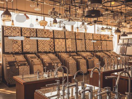 다양한 타일 샘플과 조명 기구, 수전이 진열된 자재 도매 매장 내부