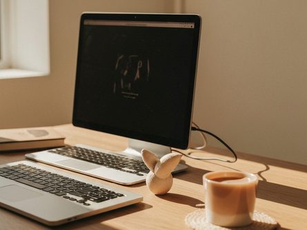 밝은 햇살이 드는 거실 한켠, 흰색 벽면에 부착 중인 우드 패턴 인테리어 필름, 손에 들린 스퀴지와 칼